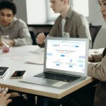 A person at a meeting with a laptop showing the Froala editor homepage.