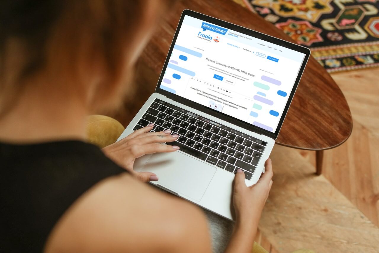 a person using a laptop computer sitting on top of a table