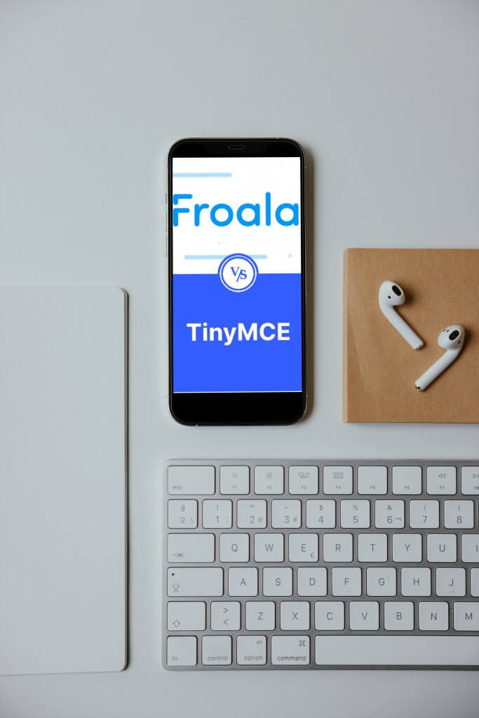 A smartphone on a desk displaying Froala vs. TinyMCE comparison on its screen.