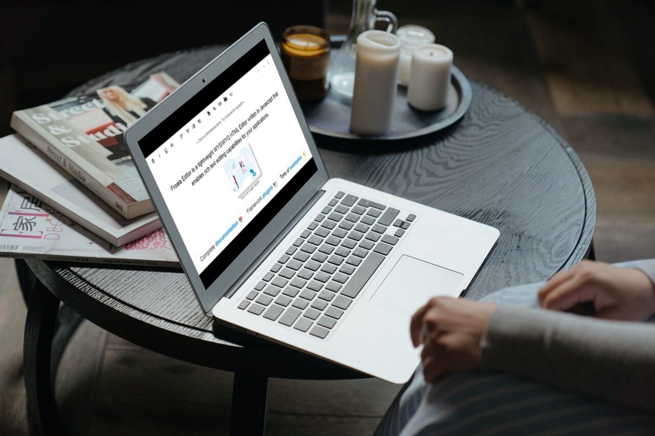 Laptop on a table displaying a Froala WYSIWYG HTML editor.