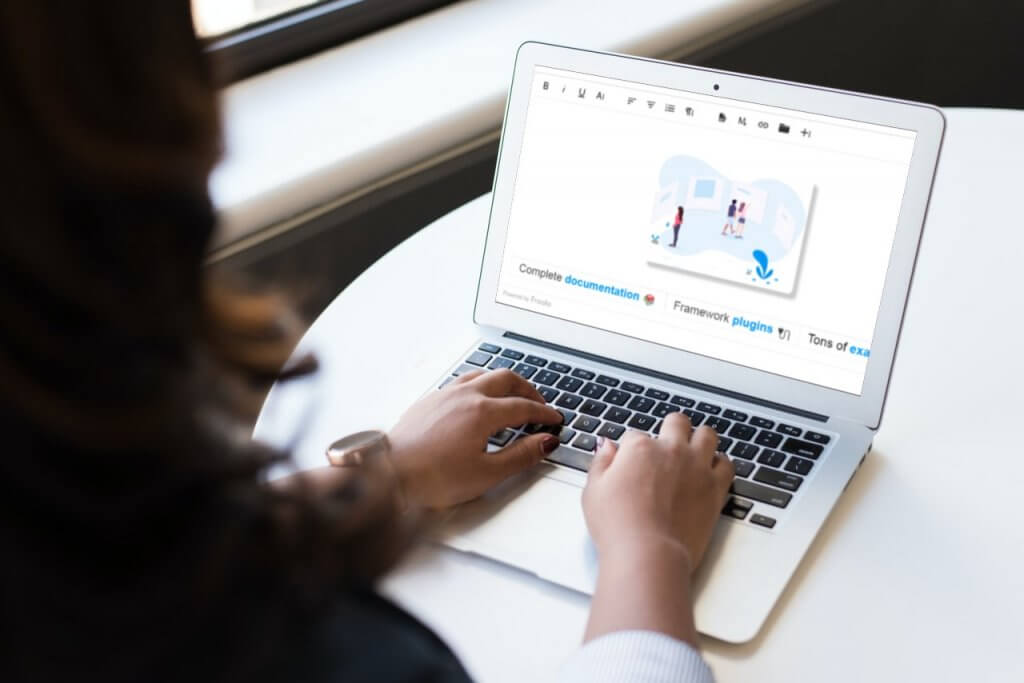 Over-the-shoulder view of a person typing on a laptop displaying the Froala Editor page.