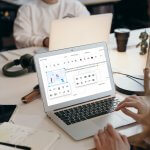 A person working on a laptop with a WYSIWYG editor open on the screen.