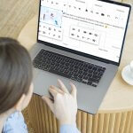 a person sitting at a table using a laptop